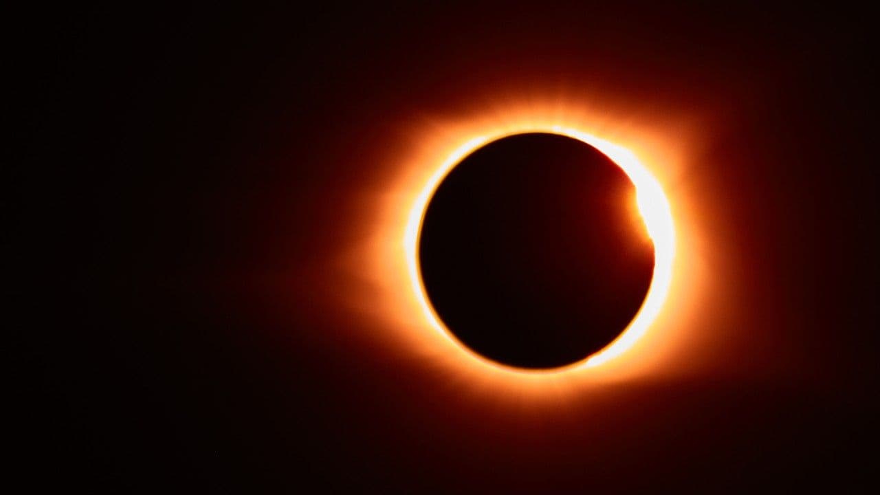 photologuephotos2023-10imagen-eclipse-solar-llamarada-solar-que-crea-resplandor-naranja-alrededor-luna-negrajpg
